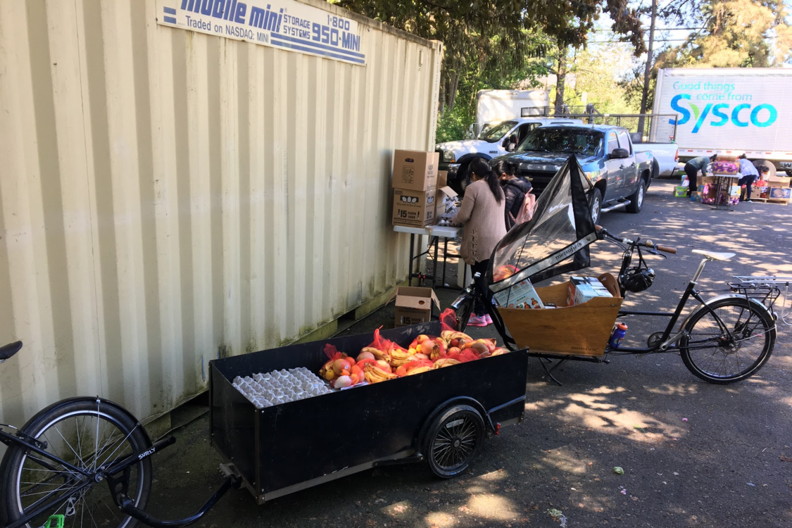 Volunteers preparing boxes of food in an outdoor setting