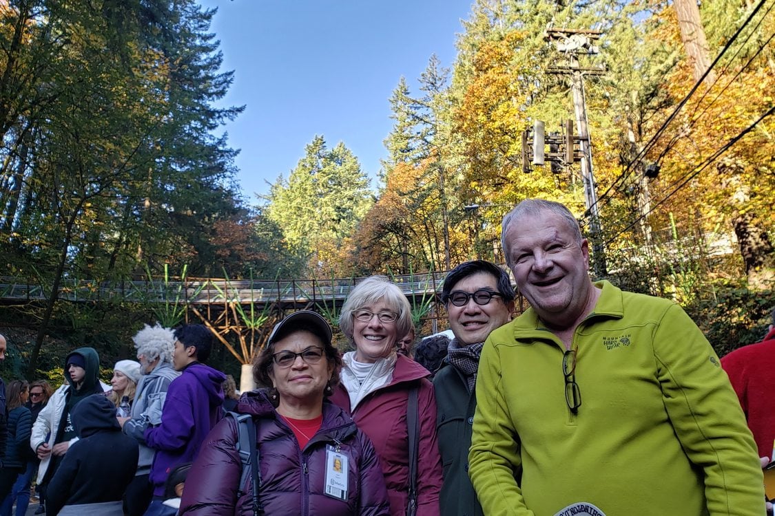 group of 4 adults gathered in front of the Barbara Walker bridge