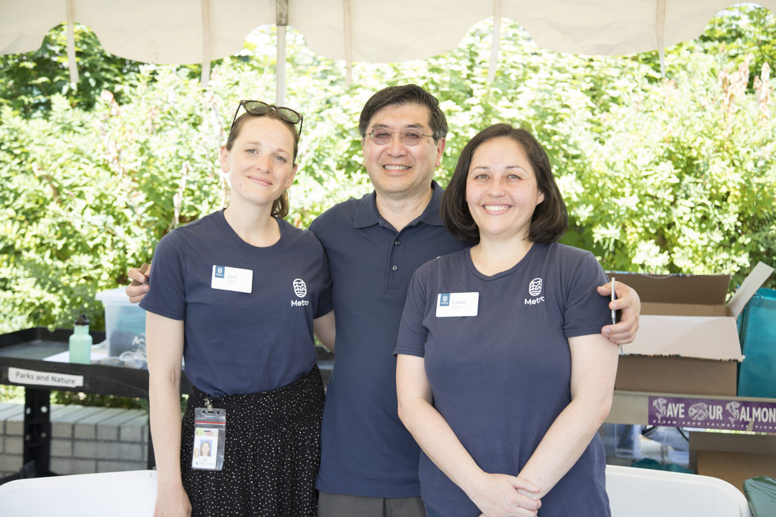 three people in navy blue shirts standing next to each other smiling