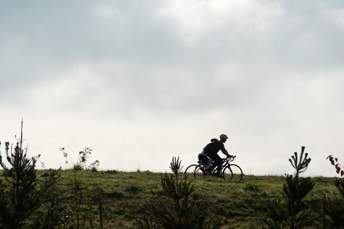 Two cyclists ride their bikes side by side along the Marine Drive trail in northeast Portland