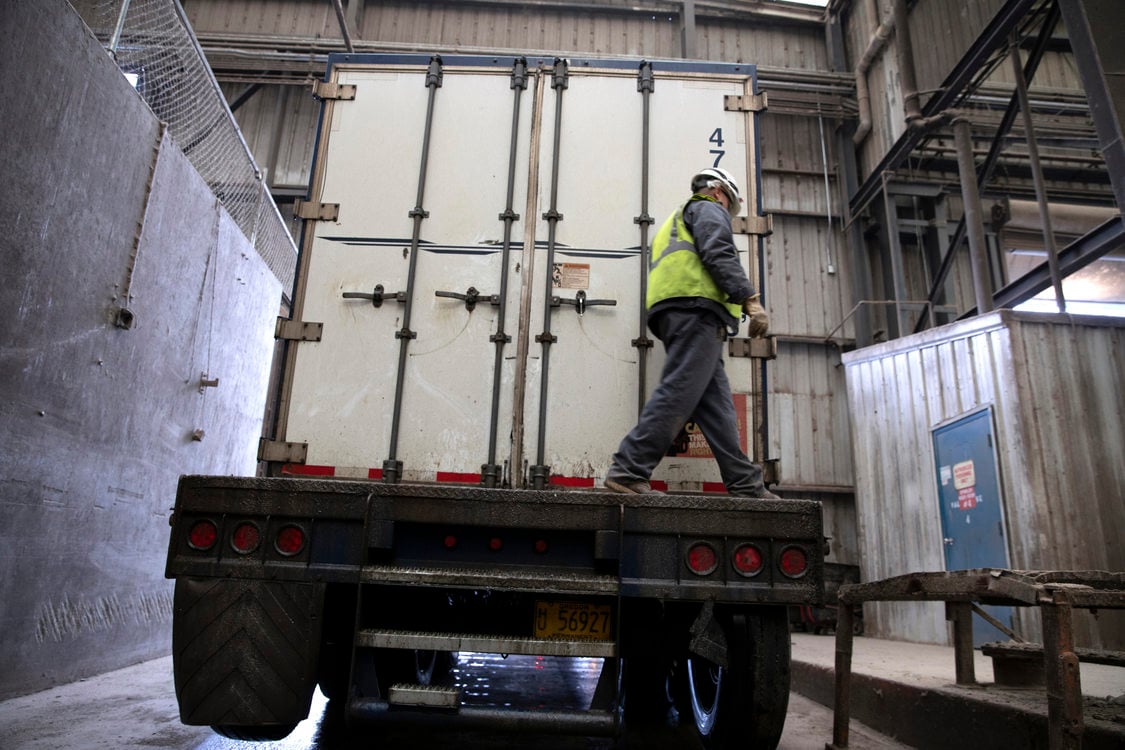 Image of Metro Central transfer station workers loading waste on a long haul vehicle