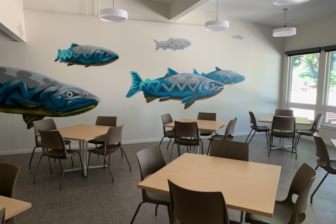 A mural of blue fish on a wall of the common area in Tukwila Springs affordable housing project
