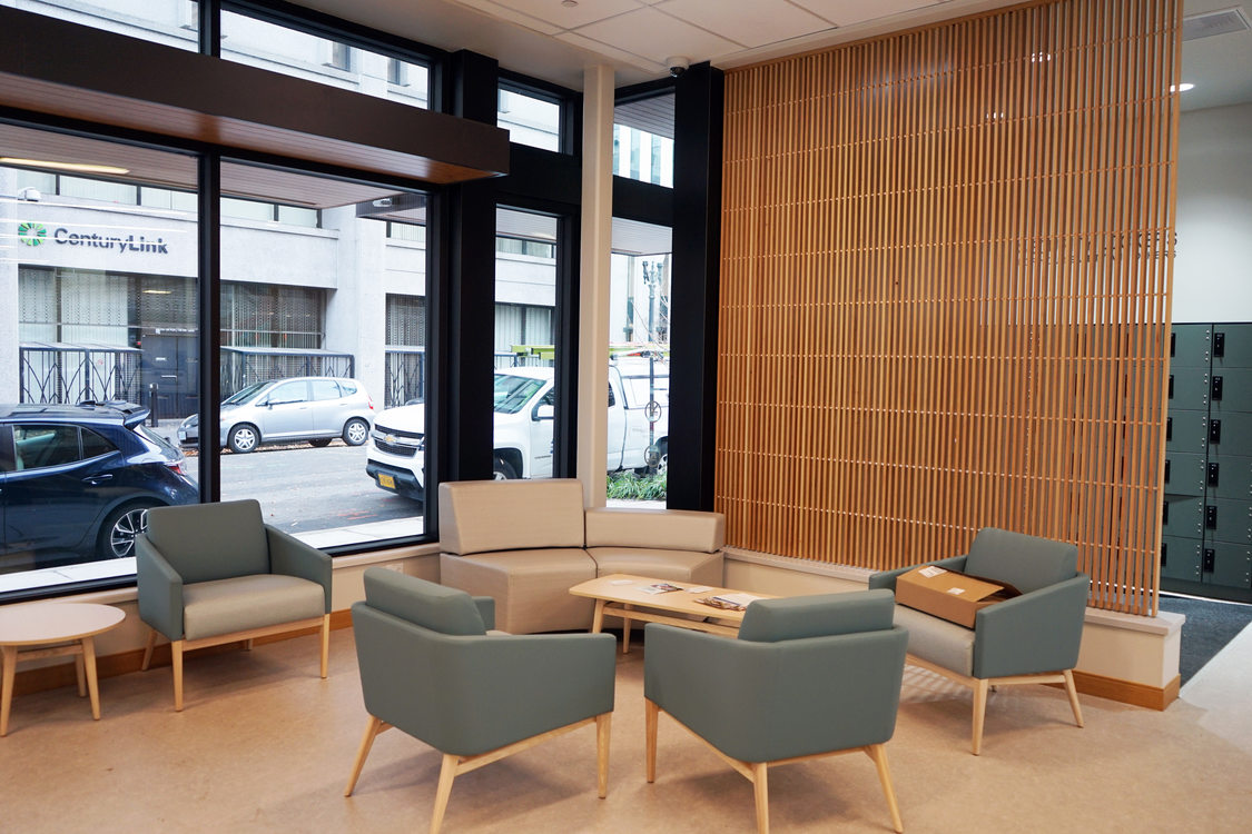 Lobby with large windows looking out onto an city street, and midcentury modern furniture