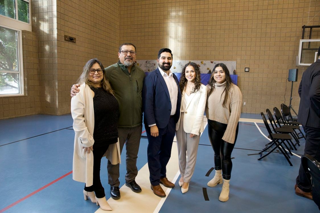 Councilor Juan Carlos Gonzalez stands with his family in a large room.