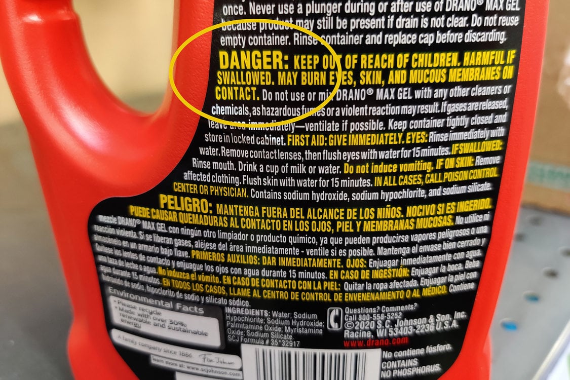 The bottom half of a red cleaner bottle, the word DANGER displays in bright yellow text against a black background
