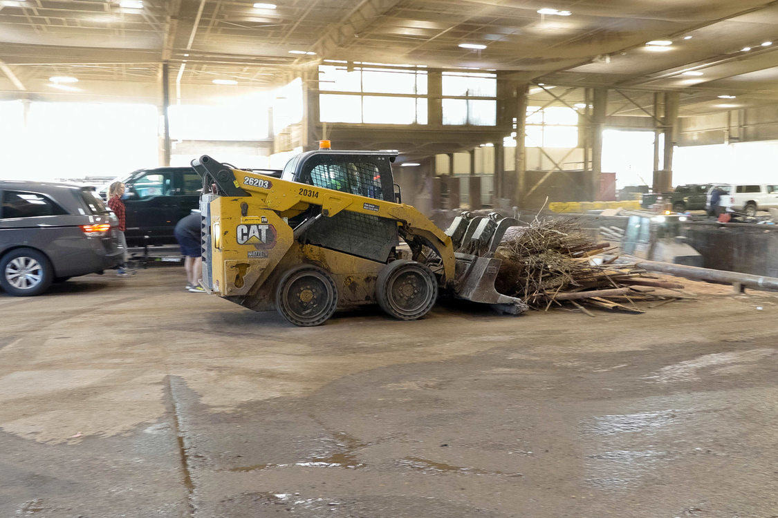 Heavy machinery pushes a pile of trash into a pit at Metro South transfer station