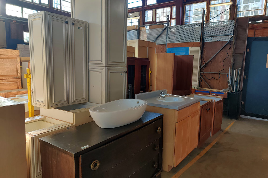 Rows of cabinets and bathroom sink countertops inside a reuse warehouse