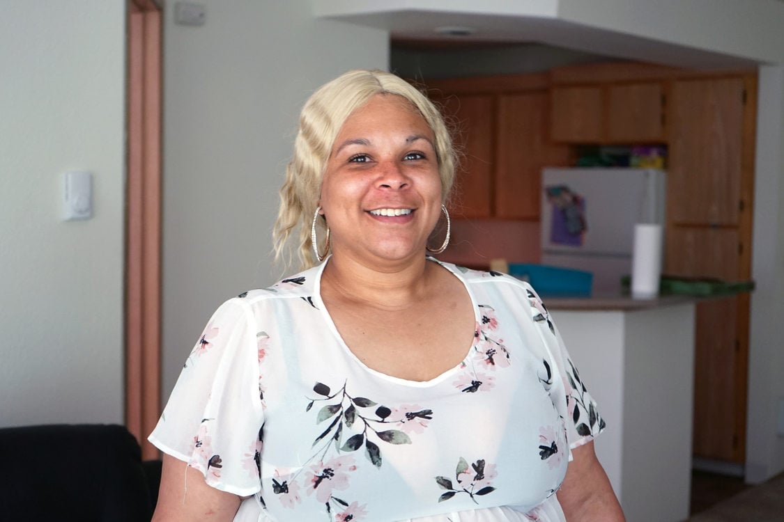 Smiling woman in white blouse with platinum blonde hair.