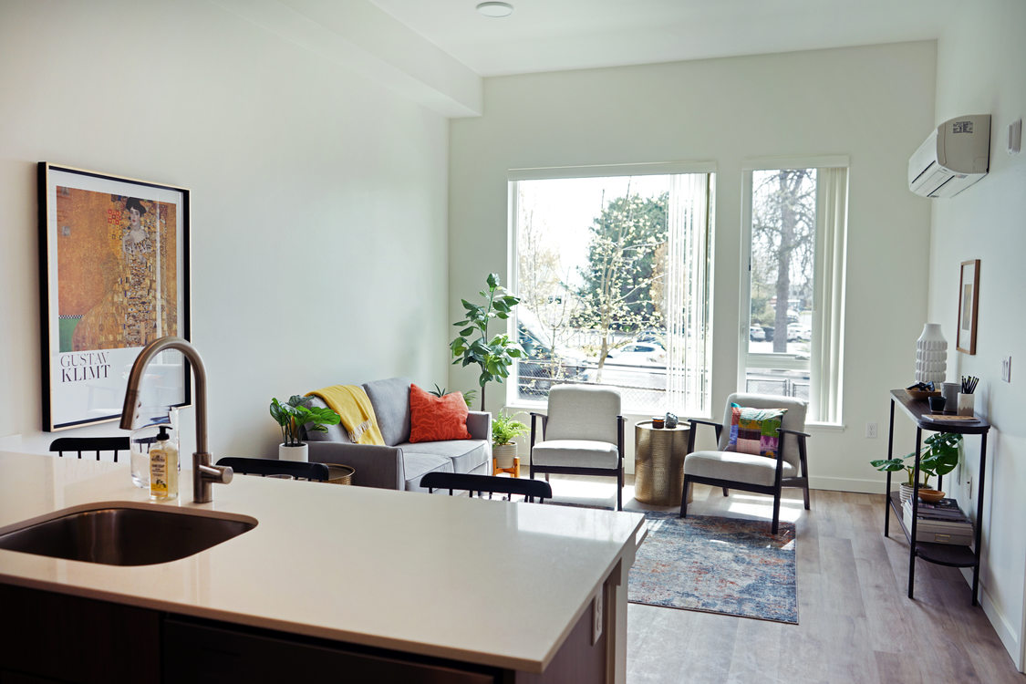 Apartment living room with sink and kitchen island in the foreground.