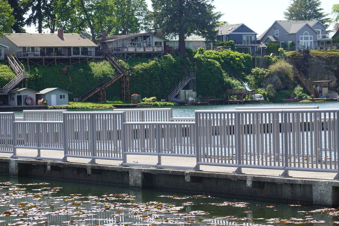 a fishing pier with metal railings that have periodic cutouts