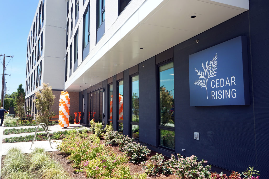Apartment building entrance from and angle, with a sign that reads "Cedar Rising."