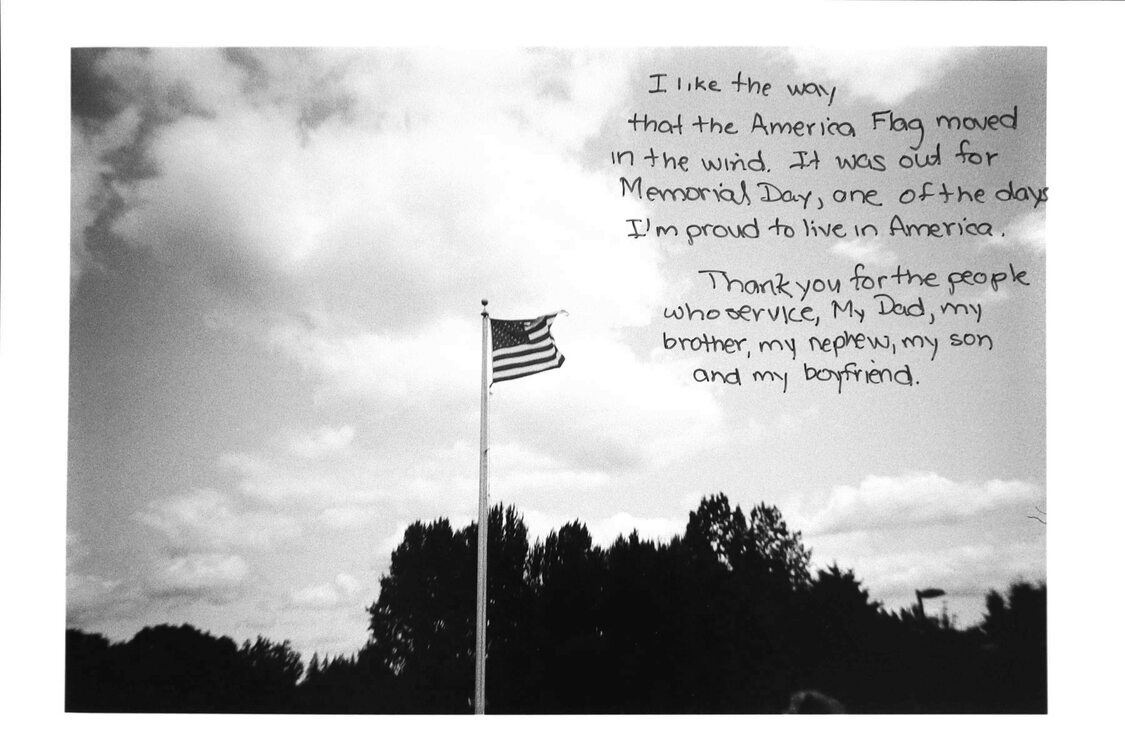 Photo of an American flag on a flag pole with writing that describes the significance of the image to the photographer.