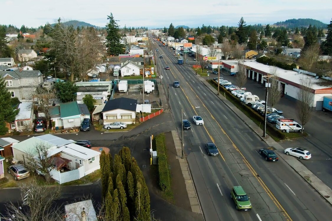 An aerial view of a four lane street and surrounding buildings.