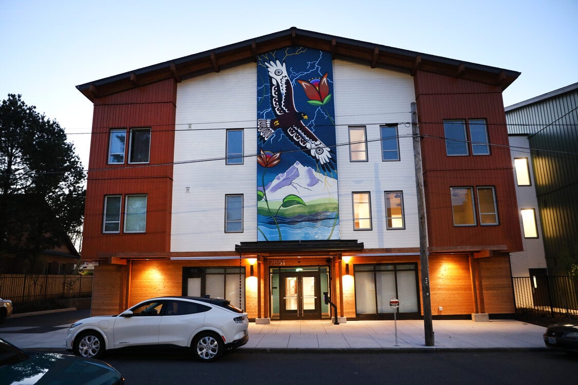 Apartment building at twilight, with vertical mural of an eagle in flight.