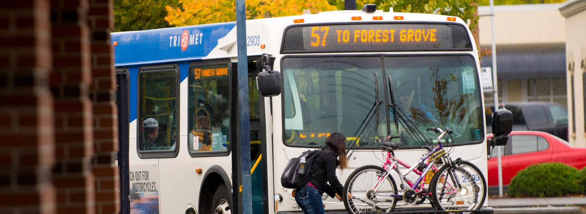 photo of woman loading a bike onto a bus