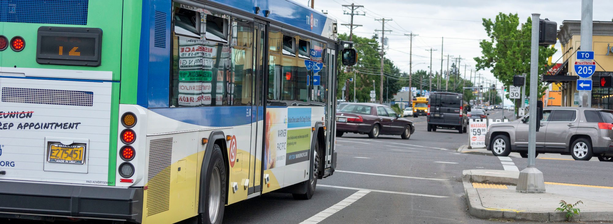 TriMet bus line 72 at an intersection on 82nd Avenue with other vehicles 