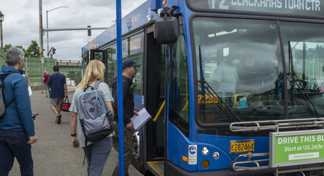 TriMet line 72 at MAX connection bus stop with riders boarding