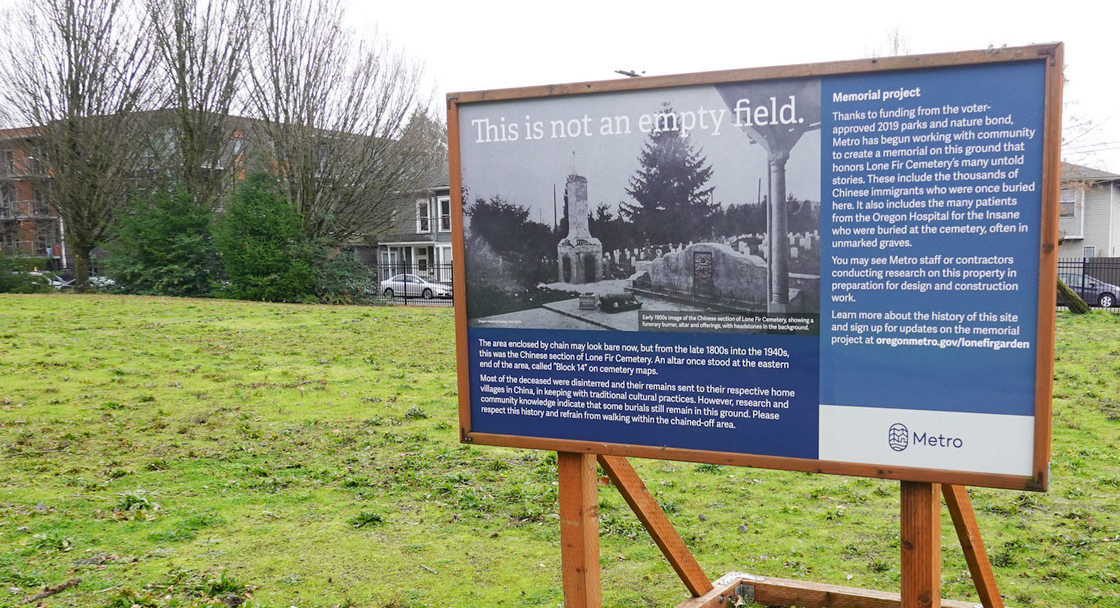 informative sign on wooden stand in a grass field; the sign has a historic photo of a Chinese altar and says "This is not an empty field."