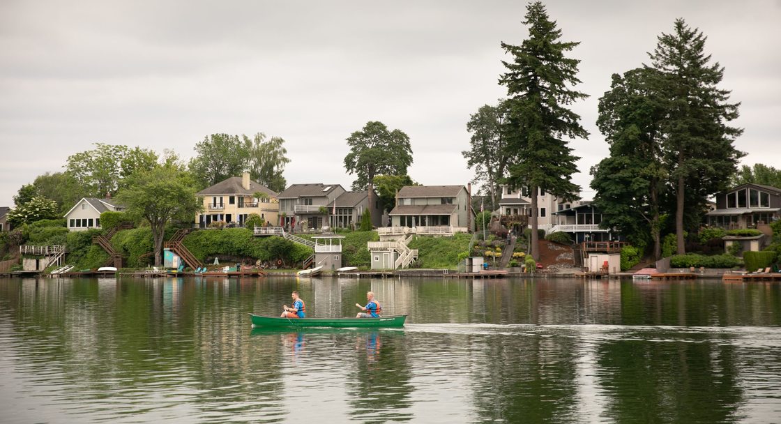 two people wearing life jackets paddling a canoe on Blue Lake
