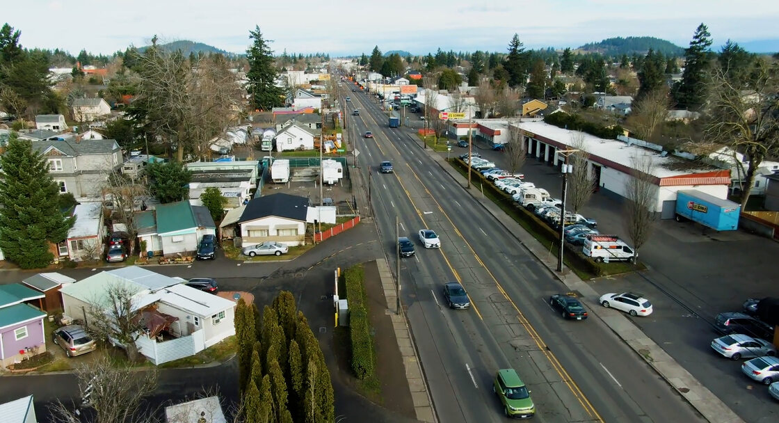 An aerial view of a four lane street and surrounding buildings.