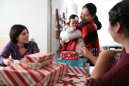 A multi-generational family gathers around holiday gifts